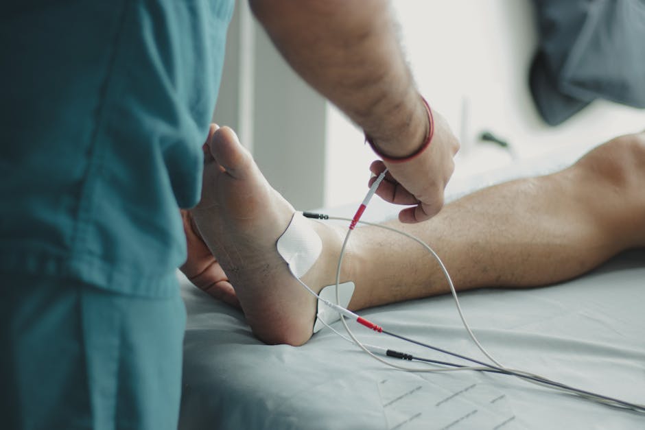 Leistungen Close-up of a healthcare worker examining a patient's foot with medical equipment in a hospital setting.