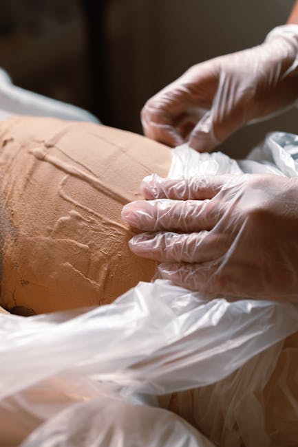 Leistungen A person receiving a relaxing body wrap treatment as part of a spa therapy session.