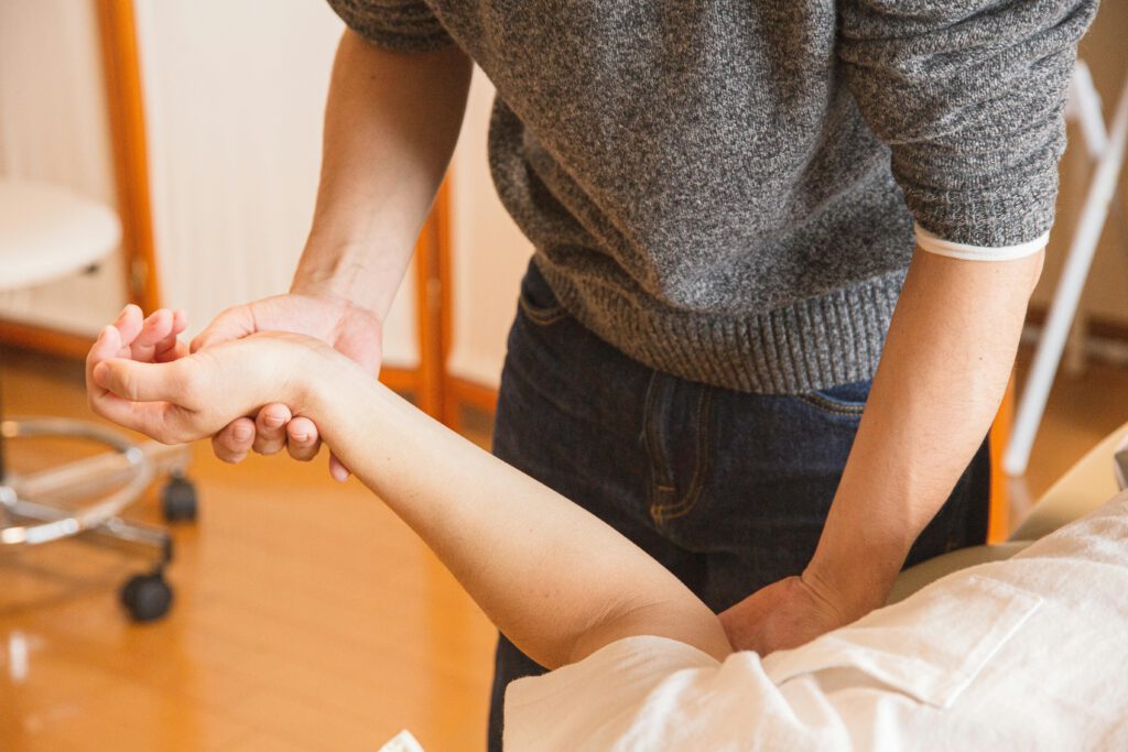 pexels photo 5473223 5473223 Crop anonymous osteopath massaging injured hand of client in process of treatment procedure