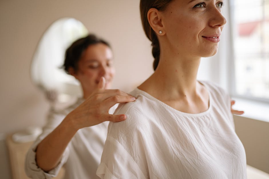 Leistungen A woman with a gentle smile experiences relaxation with a caring touch indoors.