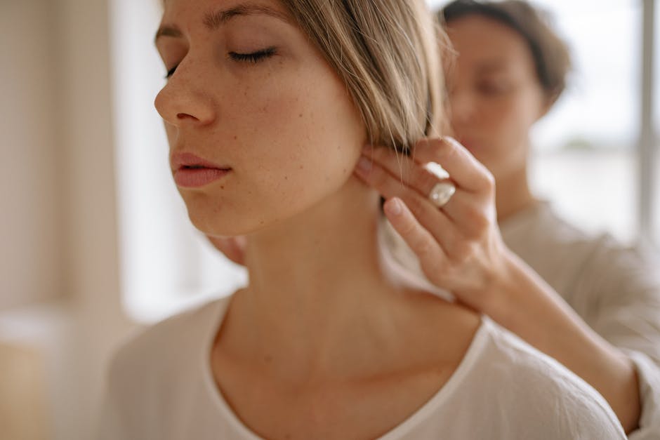 Leistungen Close-up of a woman receiving a soothing neck massage in a calm indoor setting.