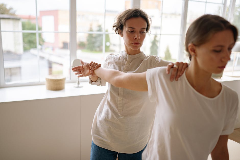 Leistungen Therapist guiding a client through stretching exercises in a calm indoor setting.