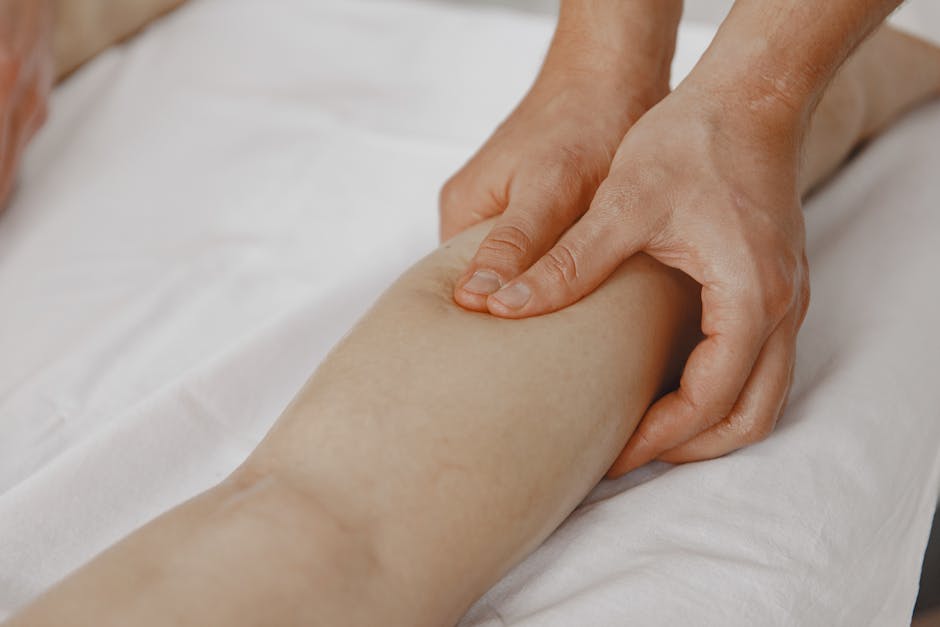 Leistungen Close-up image of a massage therapist applying pressure on a client's leg for muscle relaxation.